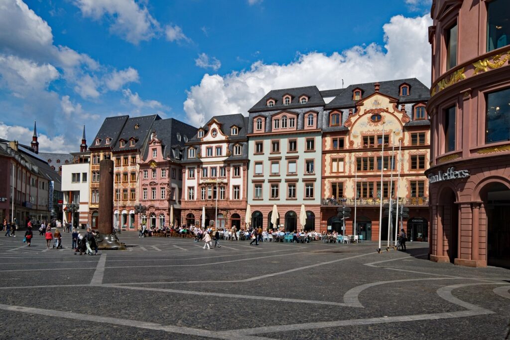 Historischer Platz mit alten Häusern und Menschen.