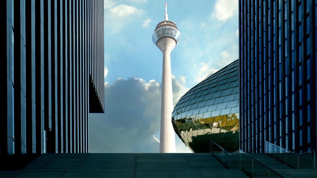 Rheinturm in Düsseldorf zwischen modernen Gebäuden