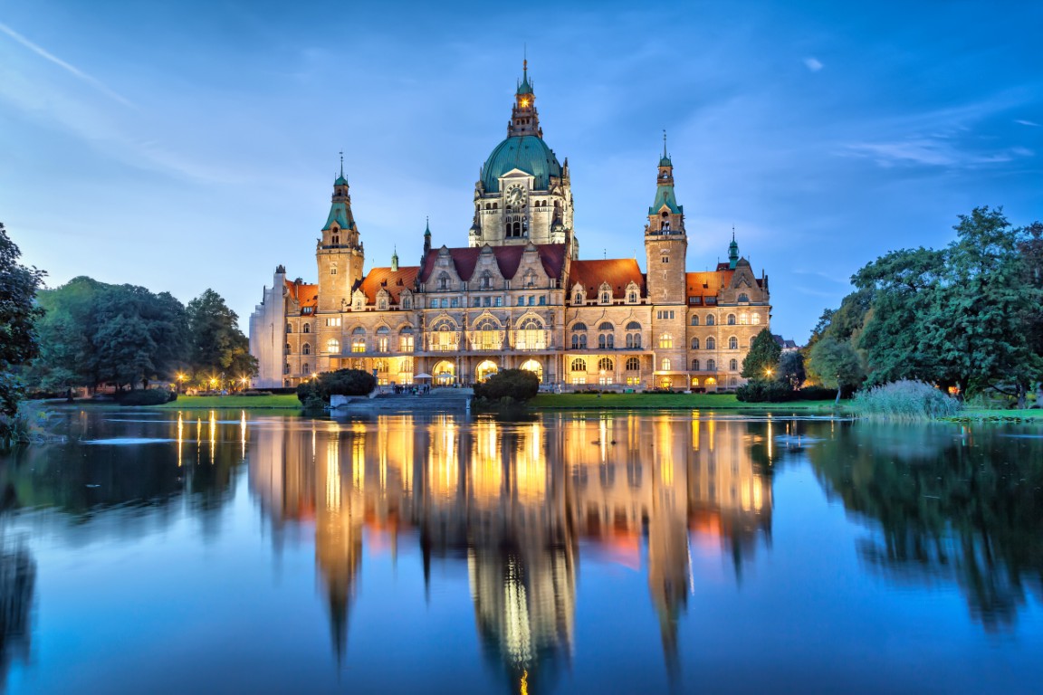 Neues Rathaus in Hannover bei Nacht, spiegelnde Lichter.